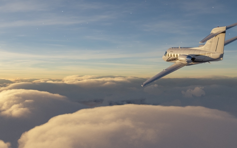Private,Jetplane,Flying,Over,The,Clouds,And,Landscape,Background,At